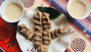 a plate of cookies and two cups of milk at Mochileros Cherry Tree House in Pelling