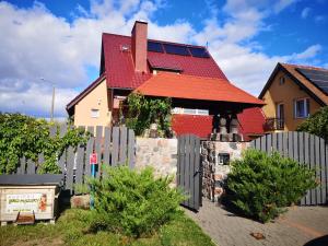 a house with a fence and a red roof at Apartament 2pokojowy 4-5osobowy in Węgorzewo