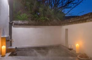 a room with two candles and a tub with smoke at Mount Emei Heyuan Serene Residence Hot Spring Hotel in Emeishan City