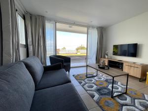 a living room with a couch and a tv at O Soleya in Saint-Joseph