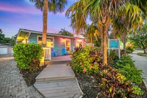 a house with palm trees and a wooden walkway at Toes in the Sand - 113 in Sarasota +50 photos