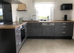 eine Küche mit Geräten aus Edelstahl und einem Fenster in der Unterkunft Wohnung Am Kreuzberg für 8 Personen in Medlingen