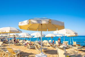 a beach with chairs and umbrellas and the ocean at Pietrablu Resort & Spa - CDSHotels in Polignano a Mare