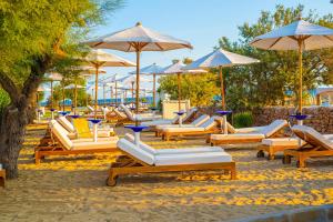 a group of lounge chairs and umbrellas on a beach at Pietrablu Resort & Spa - CDSHotels in Polignano a Mare