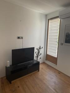 ein Wohnzimmer mit einem Flachbildfernseher auf einem Tisch in der Unterkunft St Cyprien superbe maison de village in Saint-Cyprien