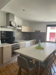 eine Küche mit einem Tisch und einer Uhr an der Wand in der Unterkunft St Cyprien superbe maison de village in Saint-Cyprien + 6 Fotos