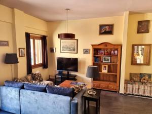 a living room with a blue couch and a tv at Syros 41 in Ermoupoli