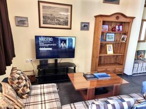 a living room with a couch and a tv at Syros 41 in Ermoupoli