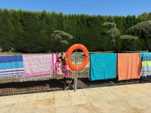 Una fila de toallas de colores colgadas en una valla en Casa en Ruta de la Plata con piscina comunitaria, en Guillena