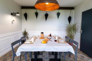 a dining room with a table with food and a light fixture at Clos sainte catherine in Rochefort-sur-Loire