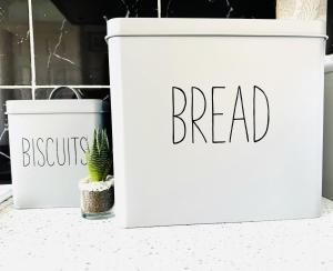 two white trash cans with the words bread and a cactus at Warren Cottage in Bridlington
