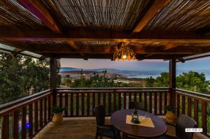 a patio with a table and chairs on a deck at Beautiful Lake View Wooden House in Tiberias