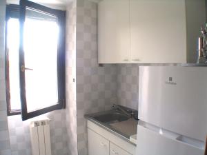 une cuisine avec un réfrigérateur blanc et un évier dans l'établissement Alloggio Via Delle Monache, 13, à Viterbe