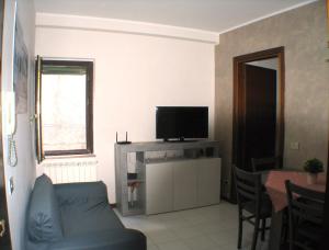 un salon avec un canapé bleu et une télévision dans l'établissement Alloggio Via Delle Monache, 13, à Viterbe