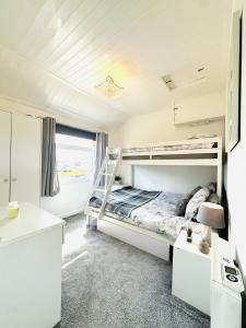 a bedroom with two bunk beds and a desk at Warren Cottage in Bridlington