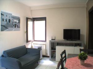 un salon avec un canapé et une télévision dans l'établissement Alloggio Via Delle Monache, 13, à Viterbe