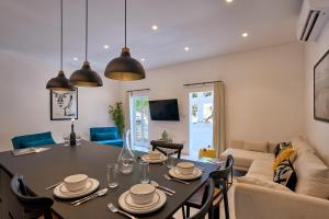a living room with a table with chairs and a couch at Marina View Apartment in Tal-Pietà