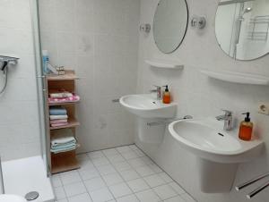 ein weißes Badezimmer mit Waschbecken und Spiegel in der Unterkunft Fewo Eichenhof in Grauel