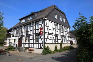 un edificio blanco y negro con techo negro en Landgasthof Reinert, en Reiste