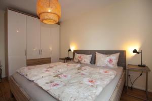 a bedroom with a large bed with pink flowers on it at Ferienwohnung Will in Bodman-Ludwigshafen