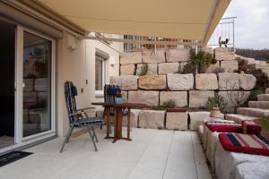 a patio with a table and chairs and a stone wall at Ferienwohnung Will in Bodman-Ludwigshafen