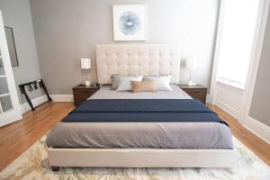 a bedroom with a large bed with a white headboard at Hoboken 15 Min Train to Manhattan Full Kitchen in Hoboken