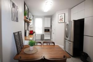 a kitchen and dining room with a table and a refrigerator at Hoboken 15 Min Train to Manhattan Full Kitchen in Hoboken
