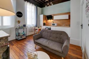 a living room with a couch and a kitchen at Le Duché - Séjour romantique avec balnéo privative - Dijon centre in Dijon