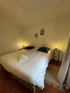 a bedroom with a large white bed with two pillows at "L'escargot" Maison familiale - Les Terres du Roy in Avallon