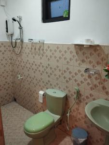 Un baño con un inodoro verde y un lavabo. en One2Five, en Kandy