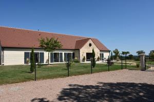 a house with a fence in front of it at Aux 3 Forêts in Bizeneuille