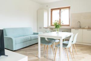 Una sala de estar con una mesa y sillas y un sofá. en Relais del Parco Verde e Relais del Parco Rosso, en LʼAquila