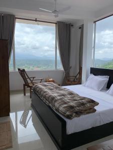 una camera da letto con un letto e una grande finestra di Galkaduwa360 Villa a Kandy