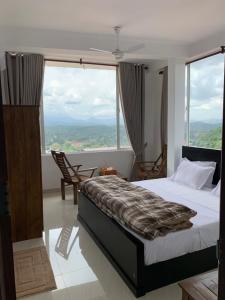 una camera da letto con un letto e una grande finestra di Galkaduwa360 Villa a Kandy