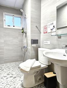a bathroom with a toilet and a sink and a shower at Jung House in Taitung City