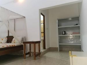 a bedroom with a bed and a desk in a room at Ndiro Beach House Kendwa in Kendwa