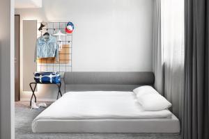 a bedroom with a bed and a rack of clothes at Moxy Cologne Muelheim in Cologne