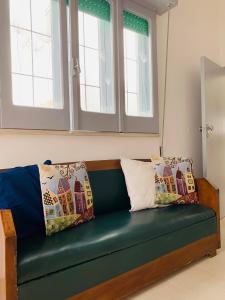 a green couch with pillows on it in a room at Dimora Paesana in Alberobello +15 photos