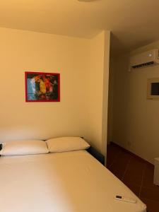 a bedroom with a bed and a painting on the wall at Villetta in pineta in Gallipoli