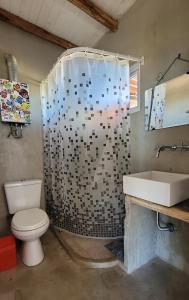 a bathroom with a toilet and a shower and a sink at Mandalei, Refugio De Mar in Las Grutas