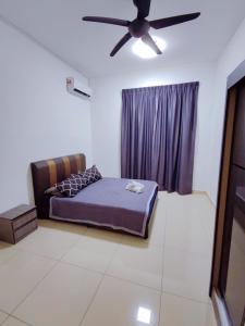 a bedroom with a bed and a ceiling fan at Spacious Family House at Desaru Harmonia 2 in Desaru