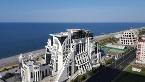 uma vista aérea de um grande edifício branco junto ao oceano em Mimino Apartment Deluxe First Line (K III) em Batumi