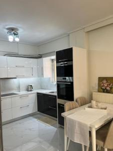 a kitchen with white cabinets and a table with a dining room at Modern and comfortable apartment 5km from center in Athens