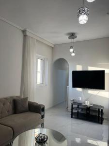 a living room with a couch and a flat screen tv at Modern and comfortable apartment 5km from center in Athens