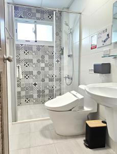 a bathroom with a shower and a toilet and a sink at Jung House in Taitung City +26 photos