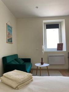 a bedroom with a bed and a couch and a table at Hyper centre - Ecusson in Castres