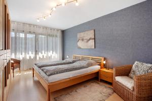 a bedroom with a bed and a chair at Ferienwohnung Lux in Plettenberg