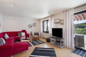 a living room with a red couch and a tv at Ferienwohnung Lux in Plettenberg