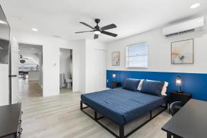 a bedroom with a blue bed and a ceiling fan at Spacious 3br Oviedo Home Save 20 Wi-fi in Oviedo