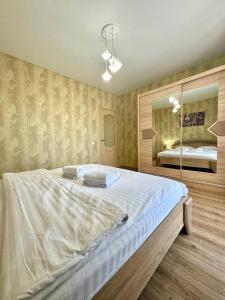 a bedroom with a large bed and a mirror at ApartPoltava НОВИЙ будинок, в самому ЦЕНТРІ 2-ОКРЕМІ кімнати, ПАНОРАМНИЙ БАЛКОН in Poltava